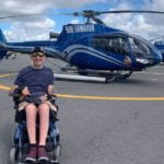 Photo of Lindsay alongside helicopter